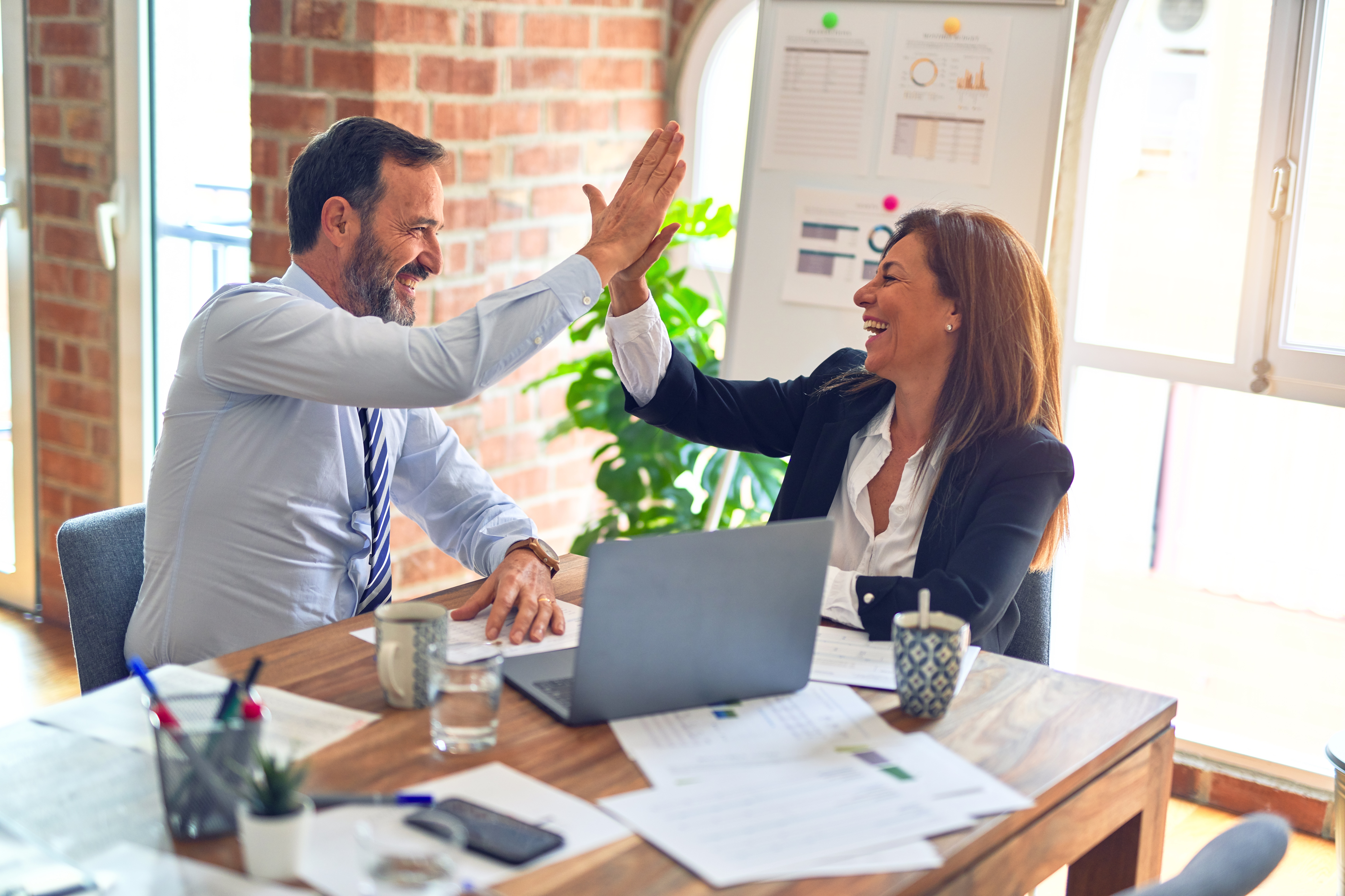 Personnes dans un bureau qui est heureuse de d'avoir remporté une affaire pour l'entreprise.